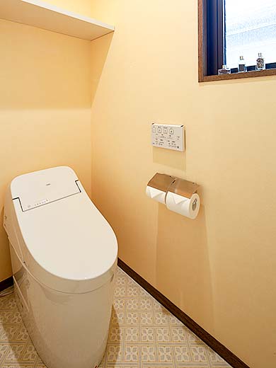 イエローの壁紙のトイレ空間